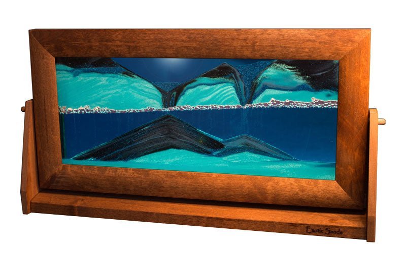 Extra-large Sandscape Sand Picture featuring flowing black and white sands suspended in vibrant blue liquid. Encased in an alder wood frame with a swivel stand, this mesmerizing, ever-changing sand art adds a dynamic touch to any home or office.