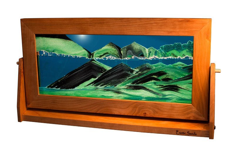 Moving sand art picture showcased in an extra-large cherry wood frame with a rotating stand, featuring a vivid turquoise liquid accented by swirling green and black sands—meticulously handcrafted in the USA.