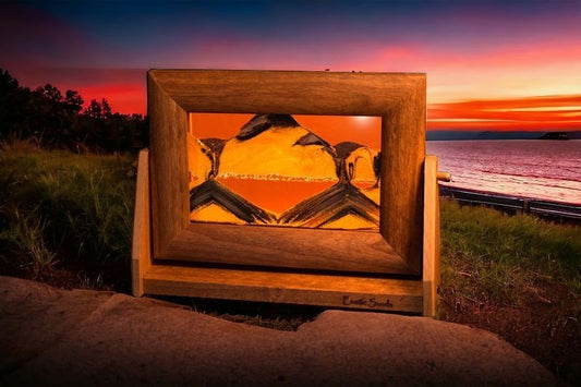 Moving sand art picture in alder wood frame with blue liquid sifting black/white sands on a swivel stand, made in USA by Exotic Sands. moving sand art pictures